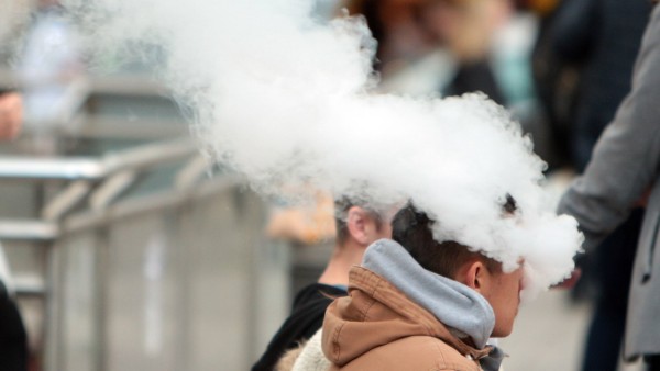 junger Mann exhaliert den Rauch einer e Zigarette in Frankfurt Hessen Deutschland