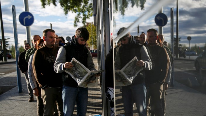 FILE PHOTO -  People wait in line to enter a government-run employment office in Madrid