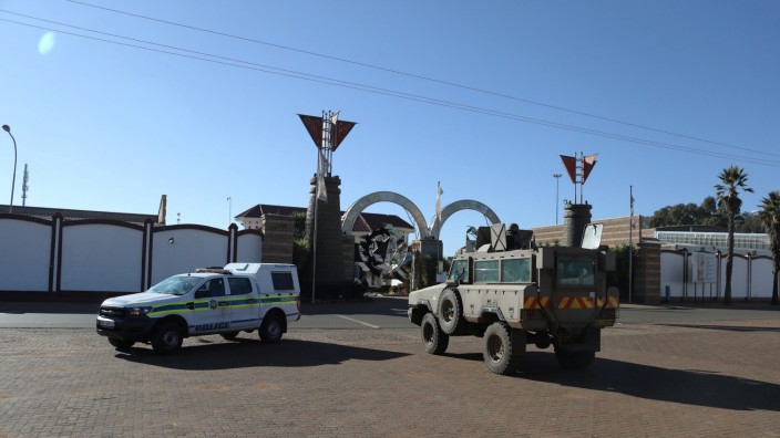 A police and a military vehicle are seen parked, as they keep watch outside a church
