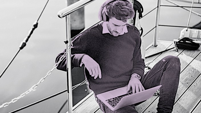 Businessman on a houseboat using laptop wearing headphones model released Symbolfoto property relea