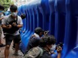 Journalists film behind water filled barriers after the opening ceremony of a temporary national security office, in Hong Kong