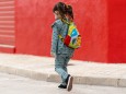 Girl walking with backpack and mask on street model released Symbolfoto EGAF00113