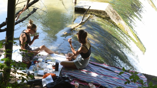 Tipps der SZ-Redaktion: Fuß im kühlen Wasser, Essen in der Hand: An der Isar findet man viele hübsche Plätze für ein Picknick.