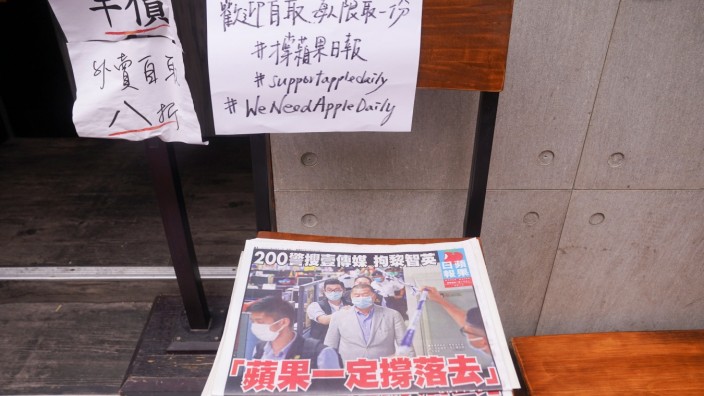 Copies of the Apple Daily newspaper with the headline 'Apple Daily will fight on', are seen outside a restaurant in Hong Kong