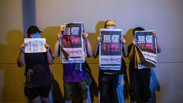 Hongkonger Zeitung "Apple Daily": Nach der Durchsuchung ließ die Tageszeitung acht Mal mehr Exemplare drucken als an einem normalen Tag: Unterstützer mit "Apple Daily"-Ausgaben.