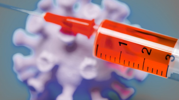 Coronavirus-Modell mit Impfspritze, Symbolfoto f¸r Covid-19-Impfstoff *** Coronavirus model with vaccination syringe, s