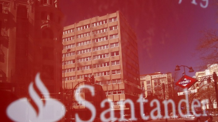 Buildings are reflect on a logo of a Santander bank branch in central Madrid