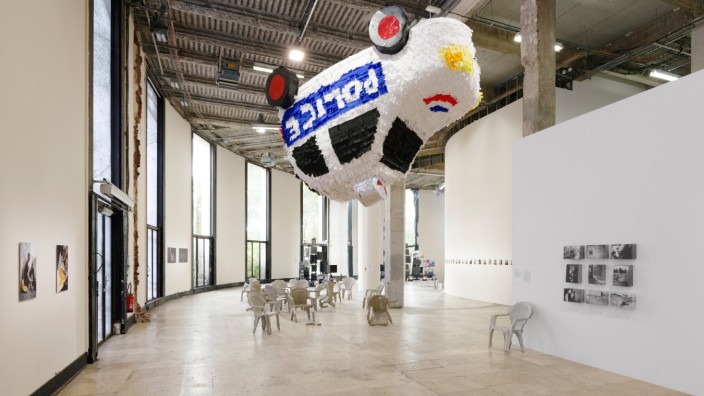 Zeitgenössische Kunst: Die Verhältnisse auf den Kopf stellen und zum Fliegen bringen: Ansicht der Ausstellung, im Hintergrund Ismail Alaoui Fdilis Beton-Stühle.