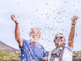 Happy senior couple celebrating with confetti outdoors model released Symbolfoto PUBLICATIONxINxGERxSUIxAUTxHUNxONLY SI