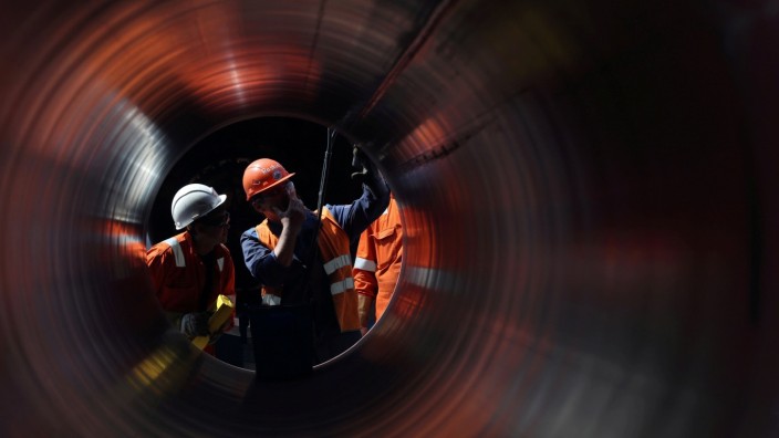 FILE PHOTO: Workers are seen through a pipe at the construction site of the Nord Stream 2 gas pipeline in Russia