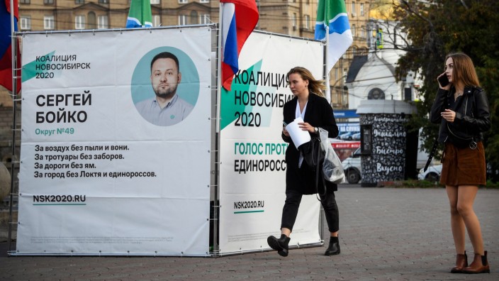 Regionalwahlen in Russland: Passantinnen vor einem Wahlplakat der oppositionellen "Koalition Nowosibirsk 2020". Auf das Büro der Partei, in dem auch Alexej Nawalnys Netzwerk seine Räume hat, wurde am 8. September 2020 ein Anschlag verübt.