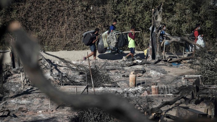 Brand in Moria: Am Donnerstag gehen Geflüchtete durch das ausgebrannte Lager Moria.