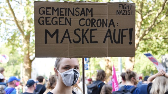 Corona-Demo in München: Mit Schild und mit Maske: eine Gegendemonstrantin am Goetheplatz.