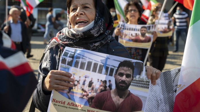 Hinrichtung von Navid Afkari: Eine Frau hält bei einer Demonstration in Amsterdam ein Bild des iranischen Ringers Navid Afkari.
