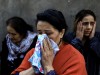 Women cry as their relatives are missing under the debris of a blast site hit by a rocket during the fighting over the breakaway region of Nagorno-Karabakh in the city of Ganja