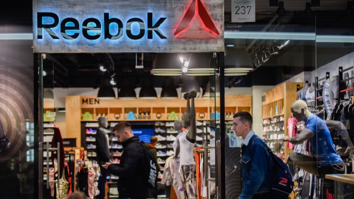 People are seen next to the Reebok shop