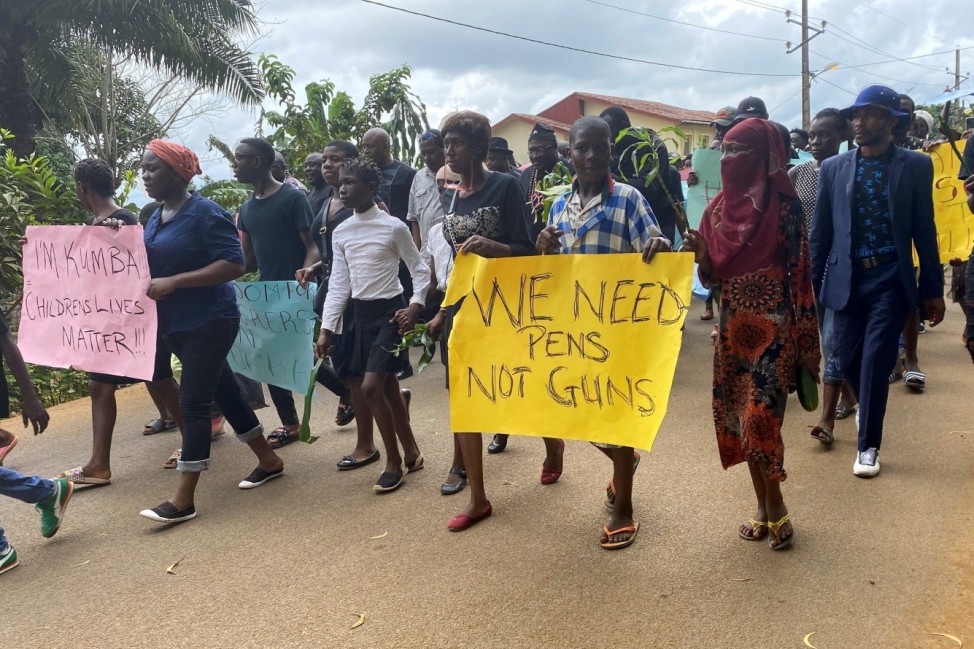 Schoolchildren, their parents and teachers hold a protest after gunmen opened fire at a school, killing at least six children as authorities claim, in Kumba