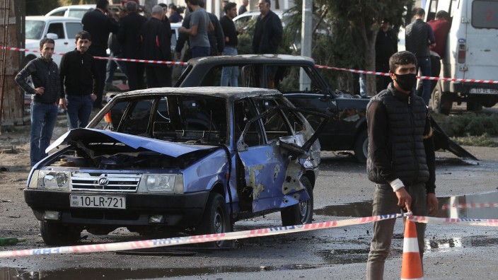 BARDA, AZERBAIJAN - OCTOBER 28, 2020: Citizens look at the wreckage of a car damaged during a military strike. Accordin