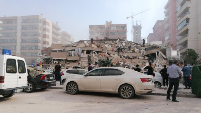 Erdbeben in der Ägäis: Menschen stehen vor einem eingestürzten Gebäude im türkischen Izmir.