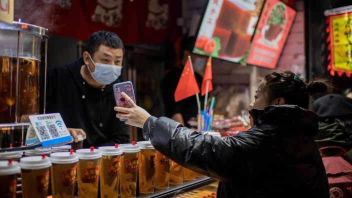 China: Eine Frau bezahlt online mit ihrem Smartphone. Das Bezahlsystem Alipay des IT-Unternehmers Jack Ma hat im chinesischen Online-Handel schon einen Anteil von rund 50 Prozent. Die Volksrepublik treibt den digitalen Yuan voran.