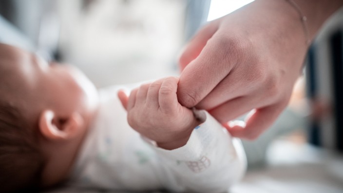 Ein Baby hält eine Hand