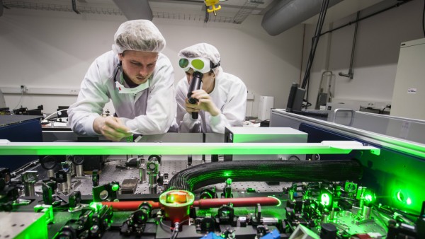 Doktoranden während ihrer Forschungsarbeit beim justieren ihres Versuchsaufbaus Laser Labor der Arb