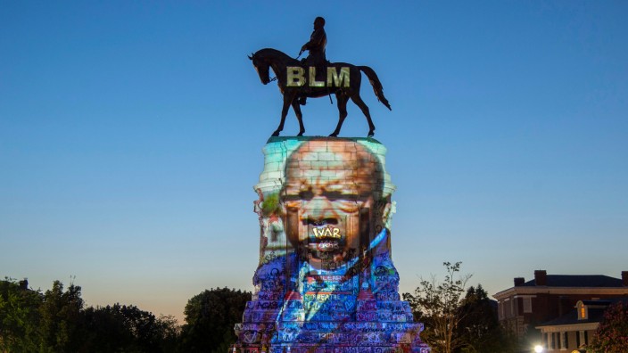 The image of late Rep. John Lewis, a pioneer of the civil rights movement and long-time member of the U.S. House of Representatives, is projected on the statue of Confederate General Robert E. Lee in Richmond