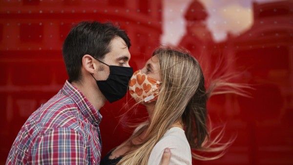 Couple kissing with protective face mask standing against acrylic wall model released Symbolfoto SASF00120