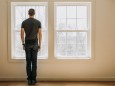 man stands in front of interior window in empty lonely minimalist room Poland, ME, United States PUBLICATIONxINxGERxSUI
