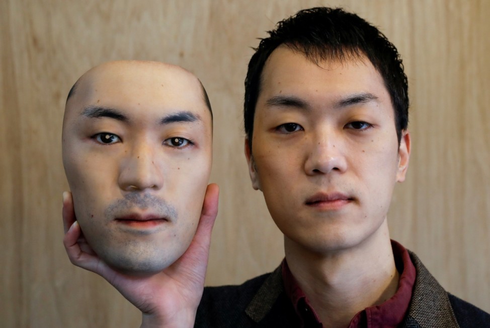Shuhei Okawara, 30, owner of mask shop Kamenya Omote, holds a super-realistic face mask based on his real face, made by using 3D printing technology, in Tokyo