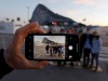 Gibraltarian citizens are seen on the screen of a mobile phone as they pose for a photo as they cross the country's border from Spanish side in La Linea de Concepcion