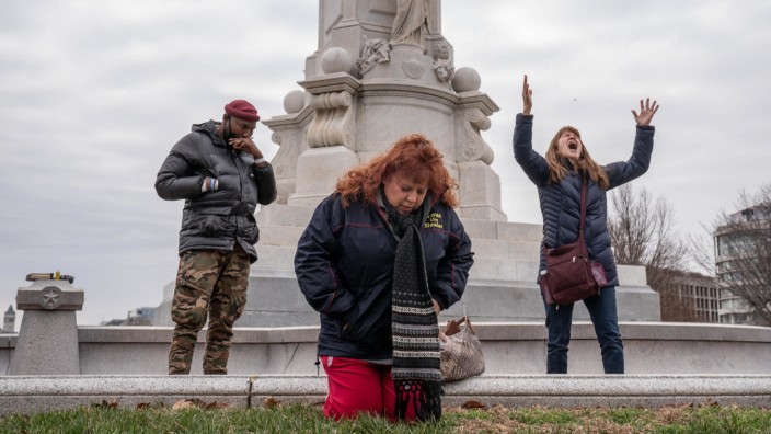 Anthony Wider, left, Starr Sumpter, center, and Tammy Ingvaldson, from Minnesota, pray to heal the land near a perimete