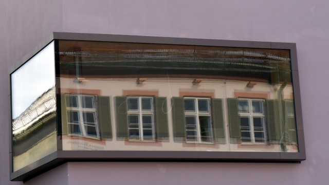 Verwaltung: Das altehrwürdige Rathaus mit grünen Fensterläden spiegelt sich im modernen Neubau.