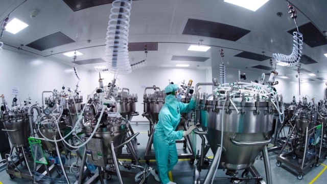 Corona-Pandemie: Mitarbeiter in Schutzkleidung bereiten Stahltanks in einem Werk des französischen Konzerns Sanofi auf die Produktion von Impfstoffen vor.
