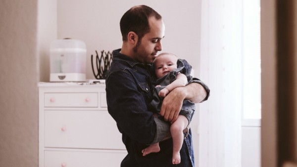 Father carrying cute baby girl in living room at home model released Symbolfoto EBBF00211