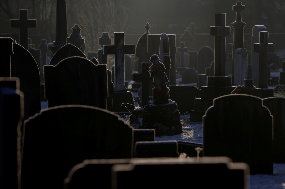 Sunlight hits frost covered headstones in a graveyard amid COVID-19 outbreak in Manchester