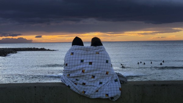 Paar während eines Sonnenuntergangs am Strand