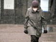 Winter wetter mit Schnee , an old women with Safety mask FFP2 is seen under the snow during the Hard Lockdown of the Co