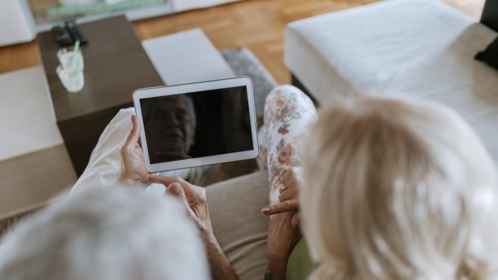 Senior couple at home sitting on couch sharing tablet model released Symbolfoto property released PU