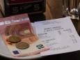 Geld liegt auf einem Teller neben einem Kassenzettel an einer Bar. Venedig, Venezien, Italien. In den Gassen der Lagunen