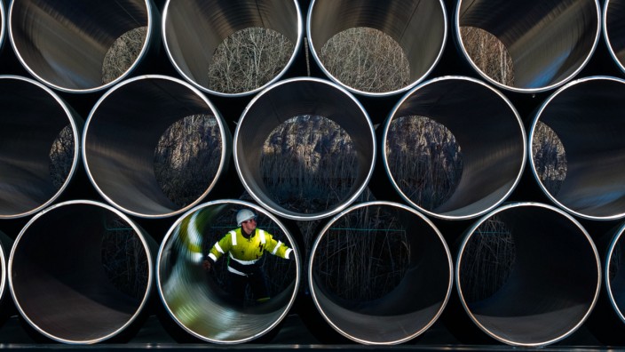 Das Politische Buch: Gasleitung ohne Gas: Ein Mitarbeiter prüft 2016 tonnenschwere Rohre für die Ostsee-Erdgas-Pipeline Nord Stream 2 auf einem Lagerplatz im Hafen Mukran.