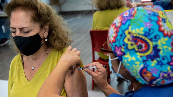 Impfen gegen Corona: Eine Mitarbeiterin des Gesundheitswesens bekommt ihre Impfdosis im Bicentenario-Park in Santiago.