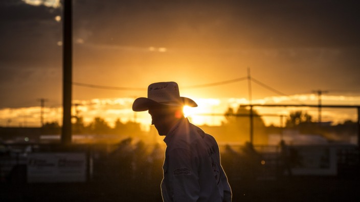 Aug 12, 2016 - Bozeman, Montana, USA - A rodeo clown interacts with the crowd at sunset during a Professional Rodeo Cowb