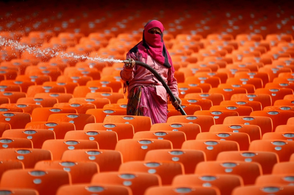 A worker cleans seats in the stands at Sardar Patel Gujarat Stadium, in Ahmedabad