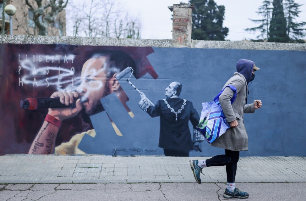 A person walks past a graffiti by Catalan artist Cinta Vidal in Cardedeu