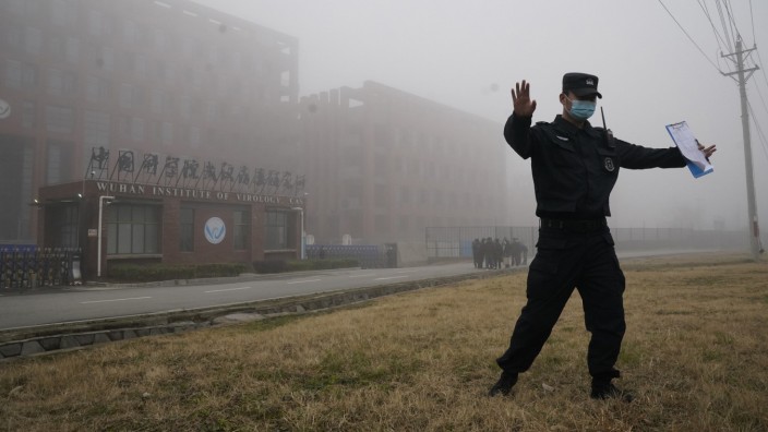Sars-CoV-2: Weg da: Ein Sicherheitsmann verscheucht Reporter vor dem Virologie-Institut in Wuhan - eine Szene vom Februar, als gerade ein Team der WHO dort war.