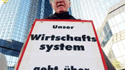 Dauer-Demo in Frankfurt: Der Theologe Gregor Böckermann klagt an - mit großen Lettern und vor der Deutschen Bank in Frankfurt am Main.