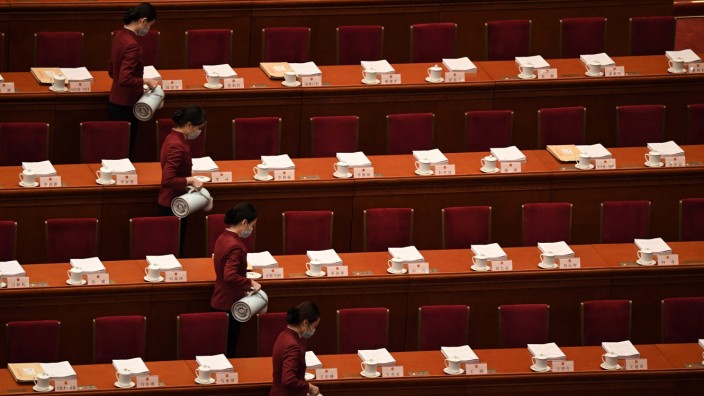 China: Reihenweise Tee für die Delegierten: Bedienstete gehen mit ihren Kannen durch die Reihen.
