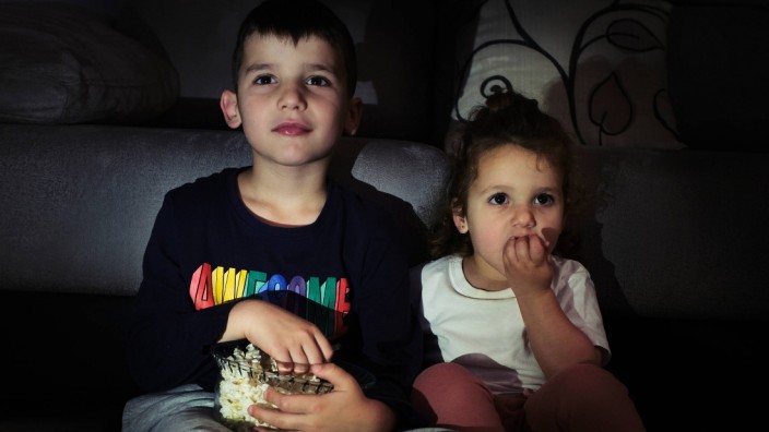 siblings watching a home movie while eating popcorn Seville, AL, Spain PUBLICATIONxINxGERxSUIxAUTxONLY CR_FAGU200508-363