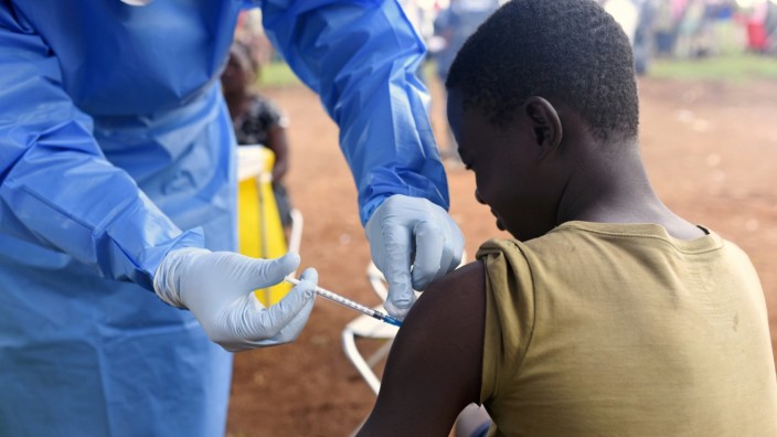 FILE PHOTO: A Congolese health worker administers Ebola vaccine to a boy who had contact with an Ebola sufferer in the village of Mangina